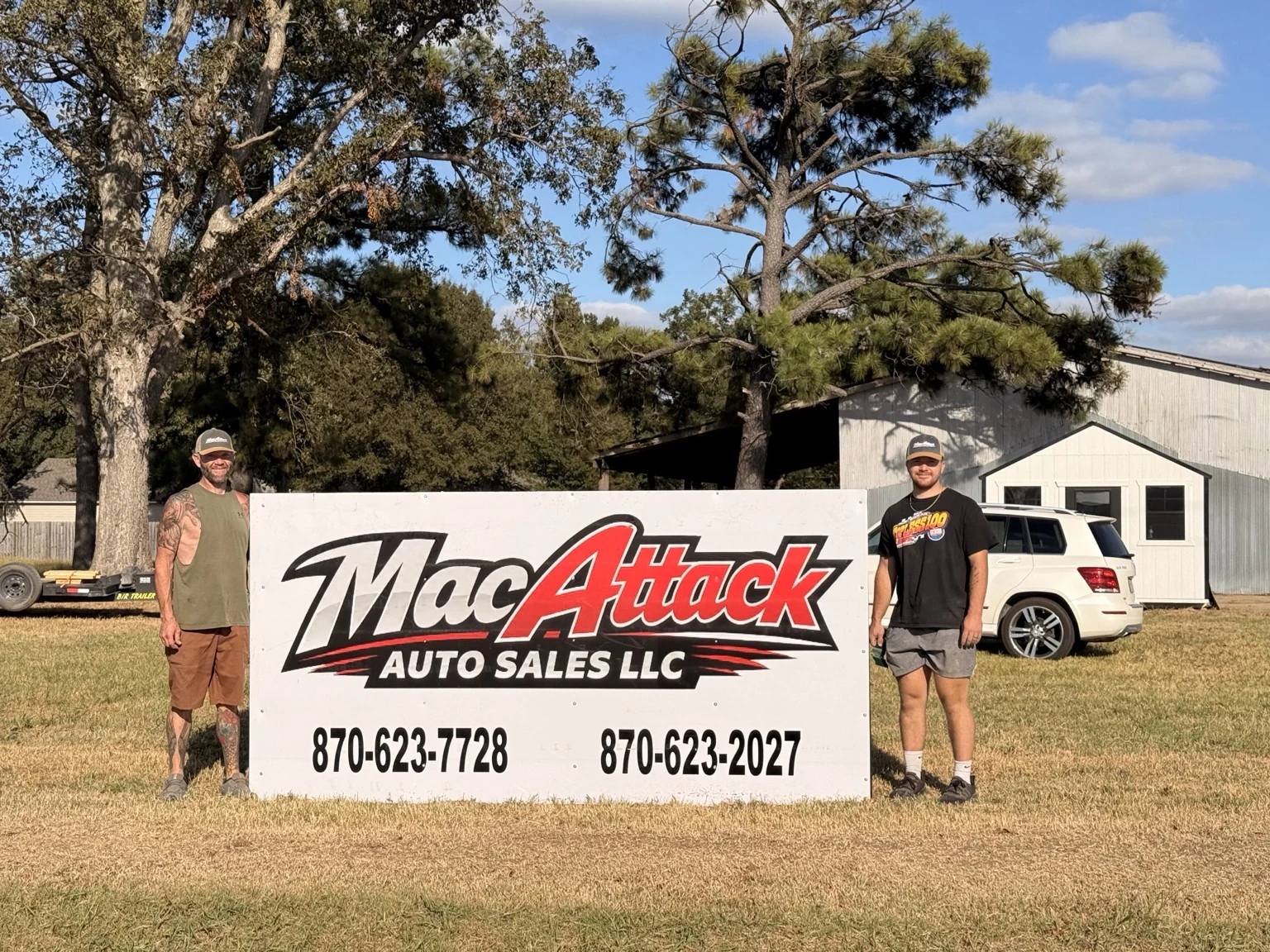 Standing beside the Mac Attack Auto Sales sign